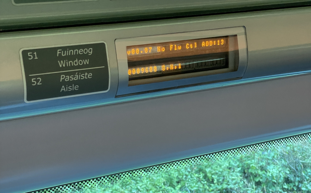 Two one-line LED displays, labeled as "Window" and "Aisle" in both Irish and English, incorrectly reading "v00.07 No Flow Ctl ADD:13" and "@009600 8,N,1"